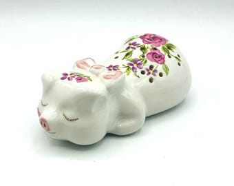 Avon 1978 porseleinen slapend varken, met de hand gedecoreerd met bloemen, houder voor potpourri. Wit met roze en lavendel.  2,5" breed x 5" lang