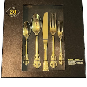 May include: A 20-piece gold cutlery set in a black box. The set includes 4 dinner knives, 4 dinner forks, 4 dinner spoons, 4 teaspoons, and 4 salad forks.