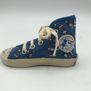 May include: Blue canvas high-top trainers with a white lace-up fastening and a Mickey Mouse and Friends logo patch. The trainers have a white rubber sole.