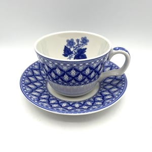 May include: A blue and white teacup and saucer set with a floral design. The saucer has a geometric pattern.
