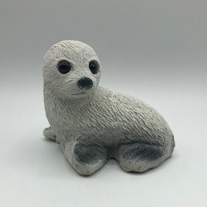 Harp Seal Pup Figurine, Sand Cast with Frosty Finish and adorable big eyes.  Weighs 1 lb. 6 oz.  5.5&quot; long and 4.25&quot; high