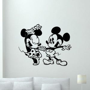 Op de afbeelding: Zwart-witte illustratie van Mickey Mouse en Minnie Mouse die dansen. Mickey draagt een rode broek en Minnie draagt een stippenjurk.