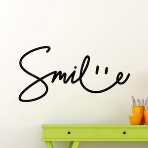 May include: Black and white wall decal with the word "Smile" written in a cursive font.