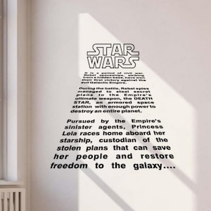 May include: A wall sticker with the Star Wars logo and a description of the film's plot. The text and logo are black on a white wall. The text describes the Rebel's first victory.