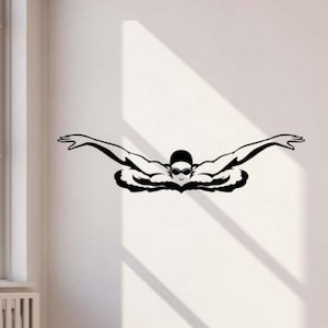 Puede incluir: Gráfico en blanco y negro de un nadador en estilo mariposa. El nadador lleva gafas y gorro, con los brazos extendidos. La imagen es una calcomanía de pared, ideal para una habitación temática deportiva.
