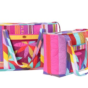 Può includere: Due colorate borse tote trapuntate. La borsa più grande ha una forma rettangolare con chiusura a zip e una tasca laterale. La borsa più piccola è una tote con un unico manico. Entrambe le borse presentano un vivace mix di colori e motivi.