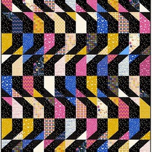 Puede incluir: Un edredón colorido con un patrón geométrico. El diseño presenta zigzags negros y blancos alternados, con secciones de telas rosas, amarillas, azules y estampadas. El edredón tiene un diseño de patchwork con varias texturas y patrones.