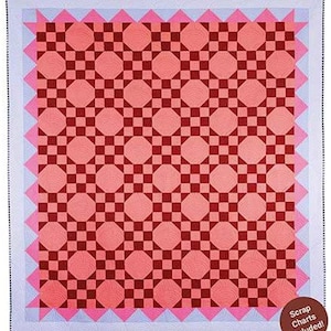 May include: A handmade quilt with a geometric pattern. The quilt features a repeating design of octagons and squares in shades of red and pink. The quilt has a pink zigzag border and a light blue outer border. The words "Scrap Charts Included!" are in the bottom right corner.