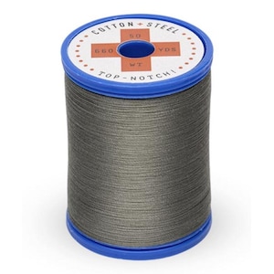 May include: A spool of gray thread with a blue top and bottom. The top of the spool has the text "COTTON + STEEL" and "TOP-NOTCH". The spool also has the text "50 WT" and "660 YDS".