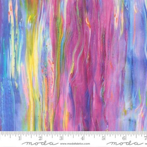 May include: A fabric swatch featuring a vertical, marbled pattern with vibrant streaks of magenta, purple, blue, yellow, and orange. A white ruler is visible at the bottom edge, showing measurements in inches, with the text moda and modafabrics.com.