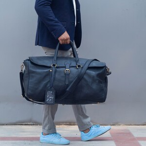 Detail of hardware and leather texture on black duffle bag