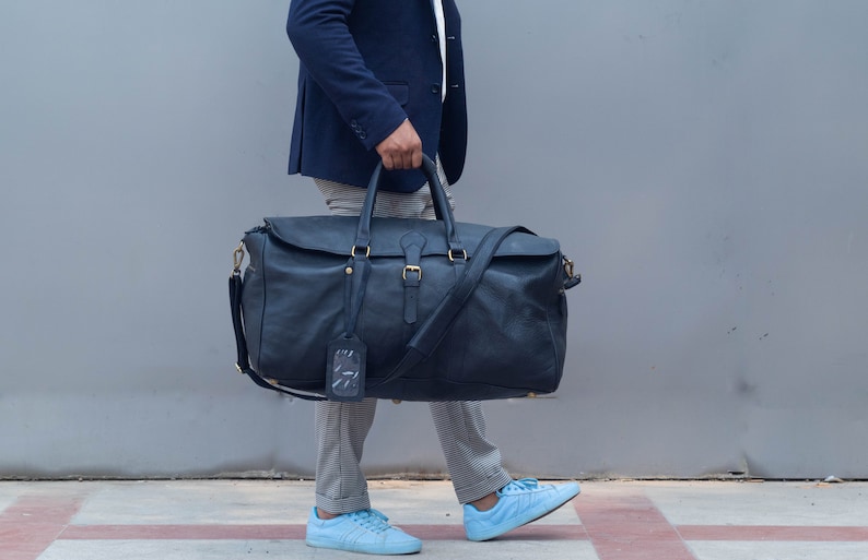 Detail of hardware and leather texture on black duffle bag