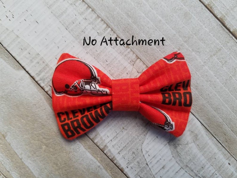 May include: Orange bow tie with a brown and white Cleveland Browns logo and the words "Cleveland Browns".