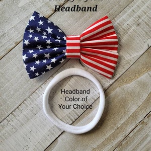 May include: A red, white, and blue American flag bow headband. The headband is made of nylon and is available in a variety of colors. "Headband Color of Your Choice" is written on the headband.