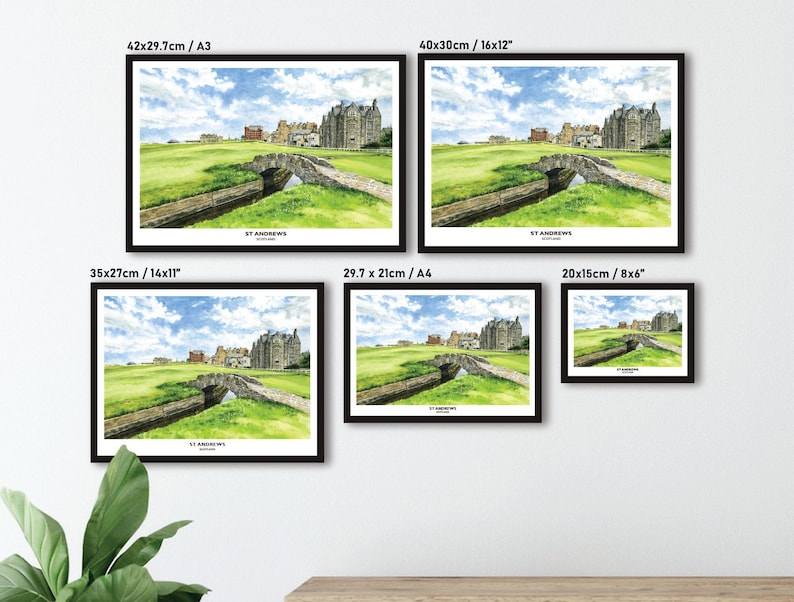 May include: Framed watercolor print of St Andrews, Scotland, featuring a stone bridge over a stream and a historic building under a blue sky. The print is available in various sizes, including 16x12 inches, 14x11 inches, and 8x6 inches.
