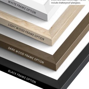 May include: Close-up of four wooden frame options: white, light wood, dark wood, and black. Each frame option is labeled with its respective color. The text in the image reads: Ready-to-hang wooden frames available in white, light brown, dark brown and black colourways. Frames include shatterproof plexiglass.
