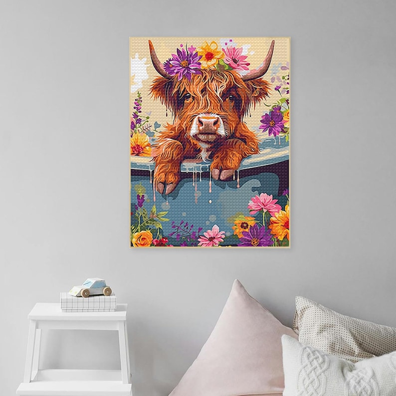 May include: A Highland cow with a flower crown is taking a bath in a blue tub surrounded by colorful flowers.