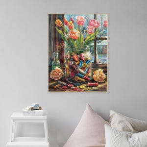 May include: A glass jar filled with colorful spools of thread, surrounded by buttons and a few pink and orange tulips. The jar is sitting on a windowsill with a view of a snowy landscape.
