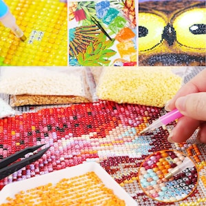 May include: Close-up of a diamond painting in progress. The image shows a colorful owl with bright yellow eyes. The canvas is covered in small, colorful diamonds, and a person is using a tool to place the diamonds. There are also small bags of diamonds in various colors.