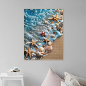 Könnte beinhalten: Eine Nahaufnahme einer Anordnung von Muscheln und Seesternen auf einem Sandstrand. Die Muscheln sind in verschiedenen Formen und Größen vorhanden, und die Seesterne sind eine Mischung aus Rot und Gelb. Der Hintergrund ist ein blaues Meer mit weißem Schaum.