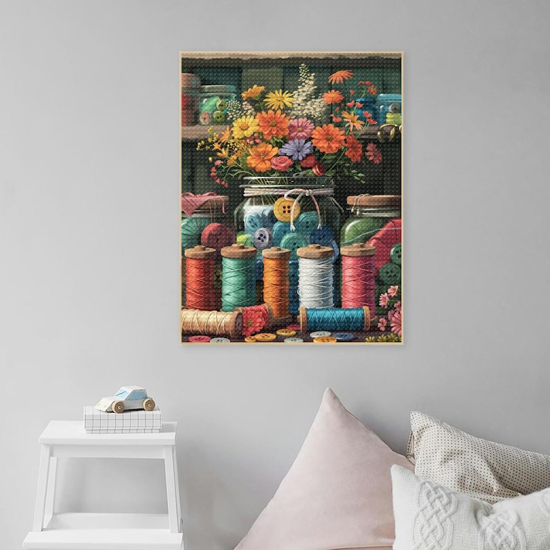 May include: A vintage still life featuring a glass jar filled with colorful buttons, surrounded by spools of colorful thread and scattered buttons. The jar is in front of a bouquet of colorful flowers.