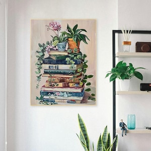 May include: A stack of vintage books with a green plant and a pink flower in pots on top. The books are arranged in a pyramid shape and have different colors and patterns. The plant is a leafy green plant with a brown pot. The flower is a pink orchid with a blue pot.
