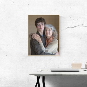 May include: A framed photograph of a young man and an older woman embracing. The man is wearing a brown shirt and the woman is wearing a beige sweater with a patterned scarf.