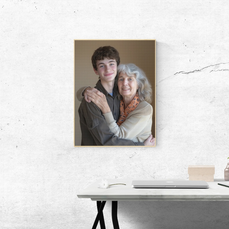 May include: A framed photograph of a young man and an older woman embracing. The man is wearing a brown shirt and the woman is wearing a beige sweater with a patterned scarf.