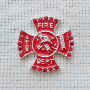 Könnte beinhalten: Eine rot-silberne Feuerwehr-Anstecknadel in Kreuzform. Die Nadel trägt die Worte "FIRE DEPT." und ein zentrales Emblem mit Werkzeugen der Feuerwehr. Die Ränder sind mit kleinen roten Akzenten verziert.