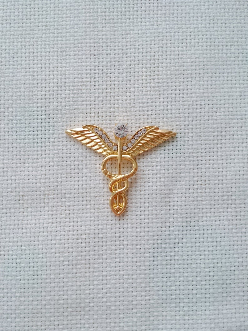 Needle Minder Medium Golden Metal Medic Emblem With Clear Rhinestones and is Magnetic