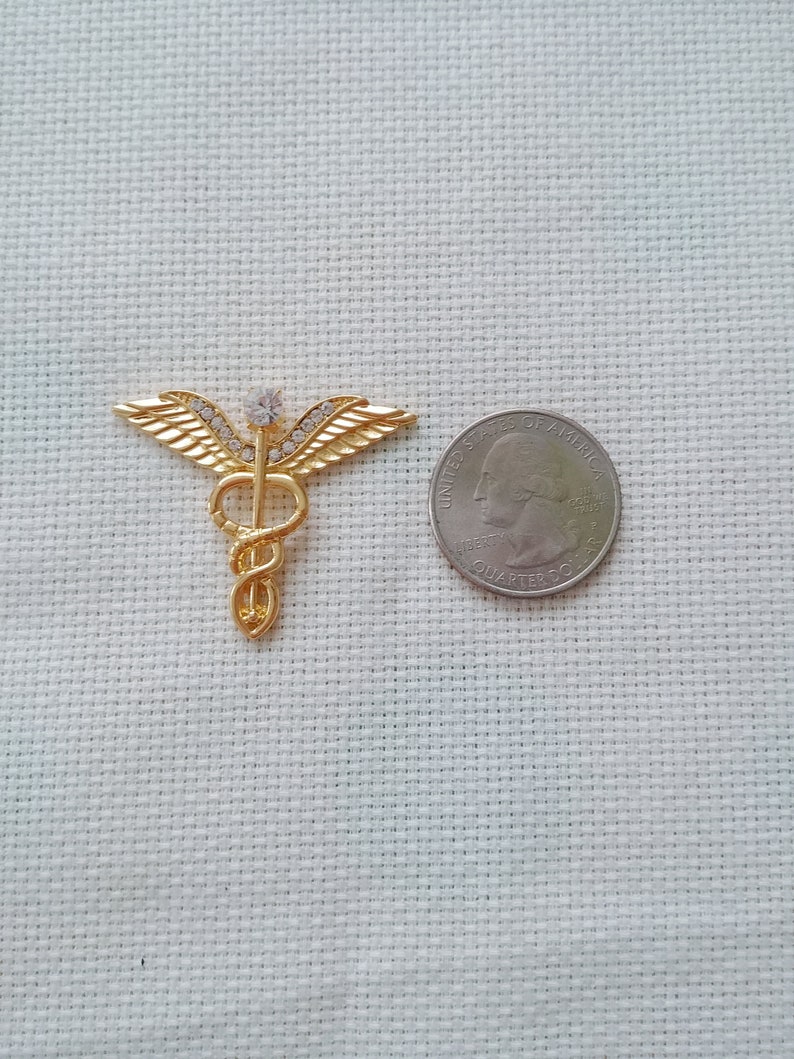 Needle Minder Medium Golden Metal Medic Emblem With Clear Rhinestones and is Magnetic