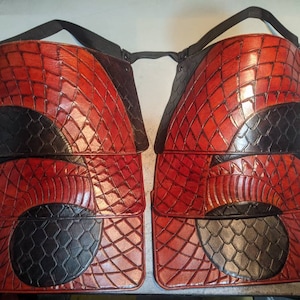 May include: Four leather panels with a red and black dragon scale pattern. The panels are stacked on top of each other.