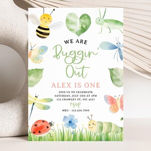 May include: A colorful invitation for a first birthday party with a bug theme. The invitation features a green heart with the text "We are Buggin' Out" and "Alex is One". The invitation also features a variety of bugs, including a bee, a ladybug, a caterpillar, a dragonfly, and a butterfly.