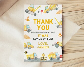 May include: A yellow and white thank you card with a construction theme. The card features illustrations of construction vehicles, including a crane, a bulldozer, and a dump truck. The text on the card reads "Thank You" and "It was loads of fun! Love, James".