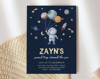 May include: A blue invitation card with gold lettering for a child's birthday party. The card features an astronaut holding balloons shaped like planets. The text on the card reads "ZAYN'S second trip around the sun" and includes details about the party, including the date, time, location, and RSVP information.