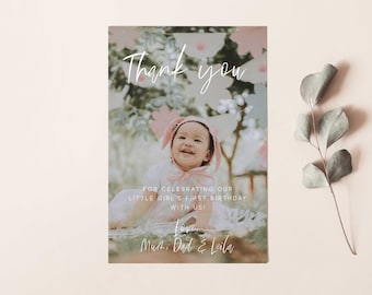 May include: Thank you card with a photo of a baby girl wearing a pink bunny costume. The card has a floral background and the text "Thank you for celebrating our little girl's first birthday with us! Love, Mum, Dad & Leila."