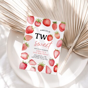 a white plate topped with strawberries next to a fan