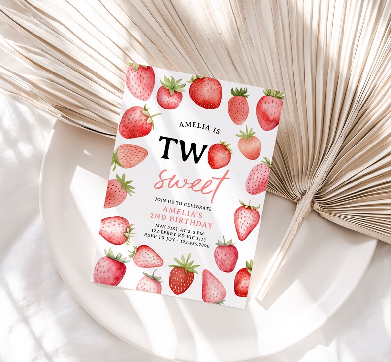 a white plate topped with strawberries next to a fan