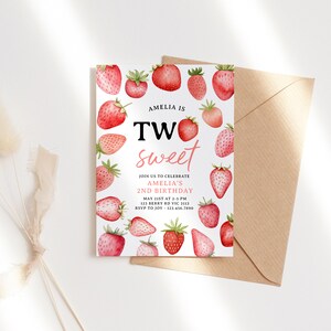 a card with strawberries on it next to a flower