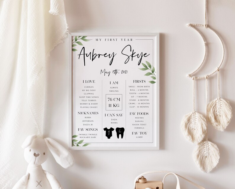 May include: A white printable poster with green leaves and black text. The poster is a baby's first year milestone chart. It includes the baby's name, Aubrey Skye, birthdate, May 18th, 2021, and a list of milestones, including favorite things, firsts, and favorite foods. The poster also includes the baby's height and weight, 76 cm and 11 kg.