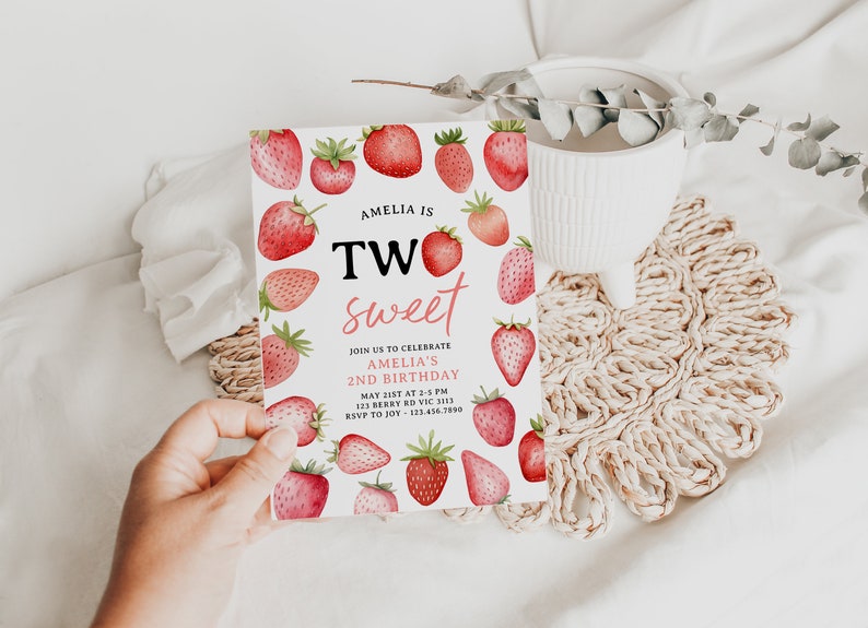 a person holding up a strawberry sweet birthday card