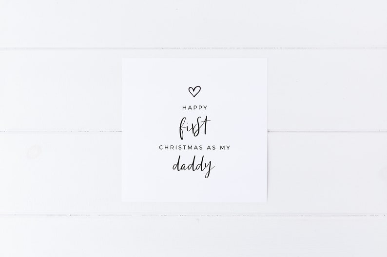 May include: A white card with black text that reads "Happy first Christmas as my daddy" with a small heart symbol above the text.