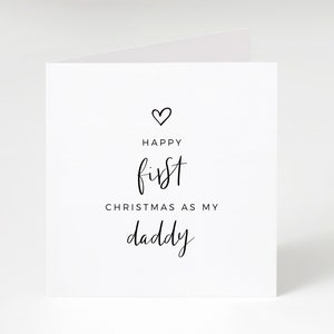 May include: A white card with black text that reads "Happy first Christmas as my daddy" with a small heart above the text.