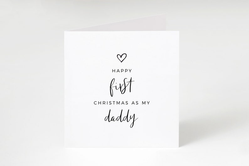 May include: A white card with black text that reads "Happy first Christmas as my daddy" with a small heart above the text.