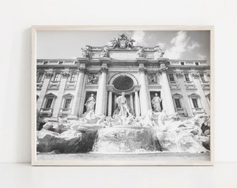 May include: A black and white photograph of the Trevi Fountain in Rome, Italy. The fountain is a large, ornate structure with a statue of Oceanus in the center. The fountain is surrounded by water and rocks.