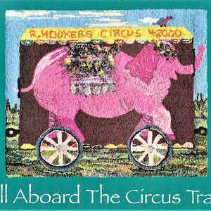 May include: A pink elephant pulling a circus wagon with the text "R. HOOKERS CIRCUS WAGON" on the side. The wagon is decorated with flowers and other colourful details. The text "All Aboard The Circus Train" is at the bottom of the image.
