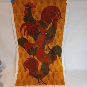 May include: A kitchen towel with a colorful design of five roosters on a yellow background with wheat stalks. The roosters are red, orange, yellow, and black.