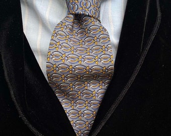 May include: A black velvet blazer with a light blue striped shirt and a patterned tie. The tie has a design of repeating gray, blue, and yellow shapes.