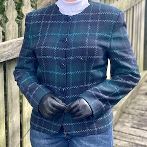 May include: A blue and green plaid blazer with a button-up front and long sleeves. The blazer is made of a soft, textured fabric.