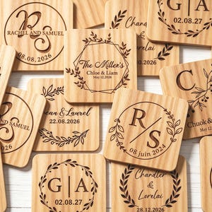 Peut inclure: Une collection de dessous de verre carrés en bois clair présentant divers motifs gravés au laser. Chaque dessous de verre affiche un texte personnalisé, incluant des noms comme Rachel et Samuel, Chloe et Liam, et des dates, entourés de couronnes florales.